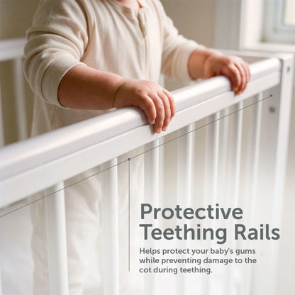 Toddler holding the protective teething rail of the Baby Elegance Kim cot