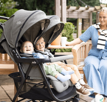 Two children sitting side by side in the Joie Signature Estrella double stroller