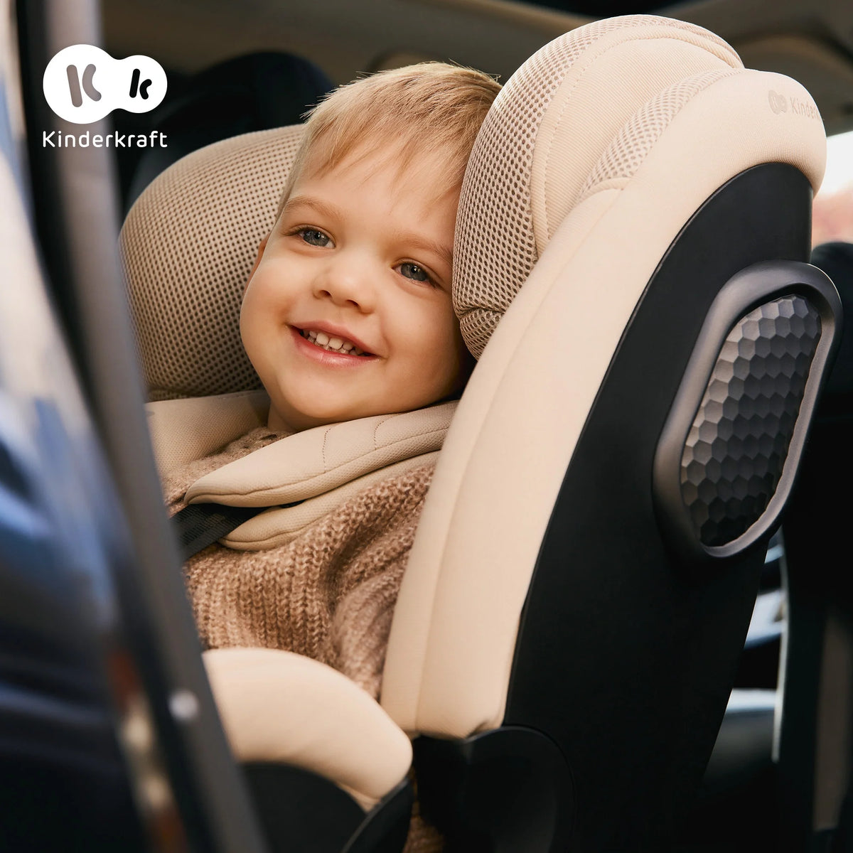Child sitting in the Kinderkraft XPEDITION 3 i-Size car seat in beige