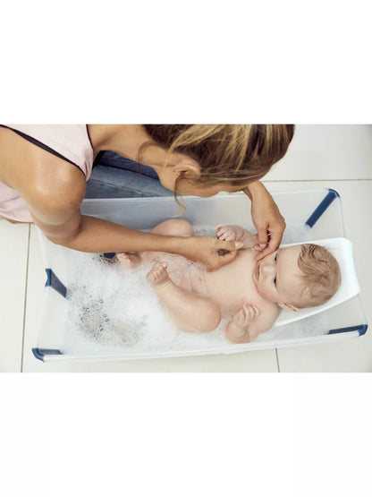 Parent bathing a baby in the Stokke Flexi Bath